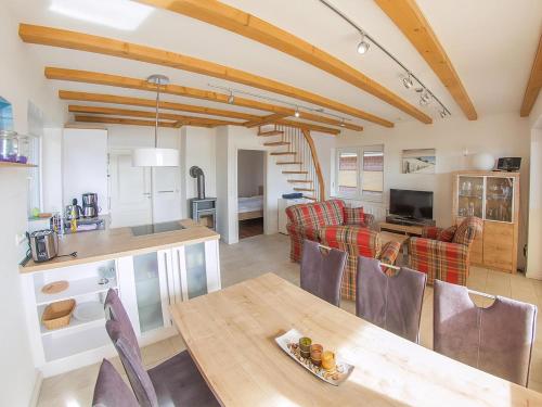 a kitchen and living room with a table and chairs at Ferienhaus Mit Atemberaubendem Blick Auf Den See in Wiefelstede
