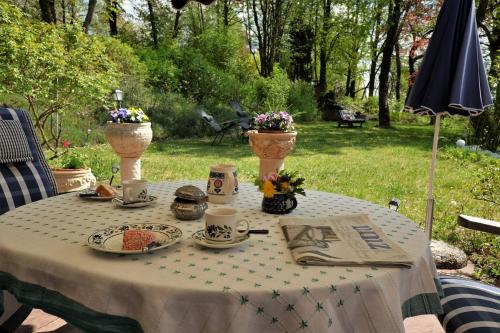 a table with cups and plates of food on it at Ferienhaus Mit Einer Umwerfenden Panoramaaussicht in Glotzdorf