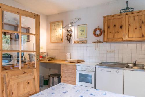 a kitchen with wooden cabinets and a white stove top oven at Löwenzahn Mit Holu in Zehdenick