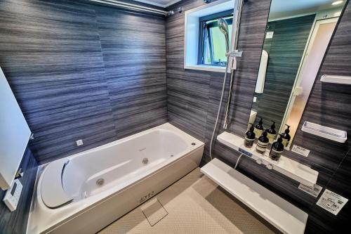 a bathroom with a white tub and a shower at IoTele南青山 in Tokyo