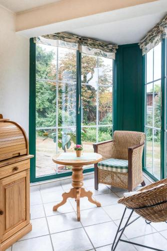 a room with a table and chairs and windows at Löwenzahn Mit Holu in Zehdenick