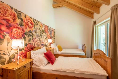 a bedroom with two beds and a flower mural at Ferienwohnung Landleben In Feistritz Ob Bleiburg in Feistritz ob Bleiburg