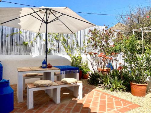 サンタ・バールバラ・デ・ネシェにあるCasa Da Aldeiaのパティオ(パラソル、テーブル、ベンチ付)