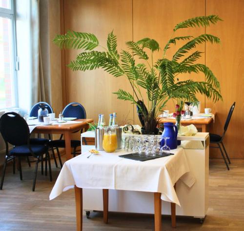 a table with a plant on it in a restaurant at Hotel Adler & Eventlocation GmbH in Itzehoe