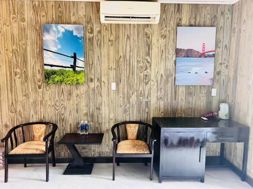 a desk with two chairs and a table and two windows at Homestay Thác Liên Khương in Ðưc Trọng