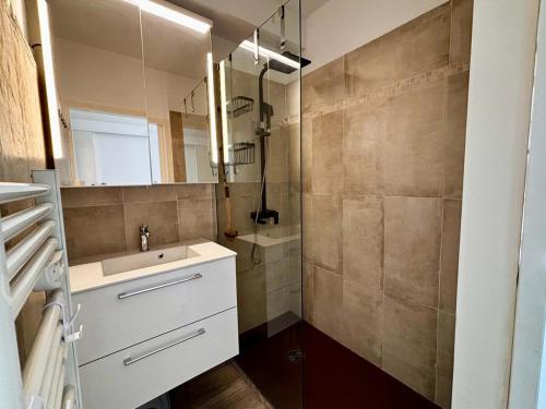 une salle de bain avec un lavabo et un miroir dans l'établissement Casamea - Studio vue mer, 2 min plage, Clim, à Ajaccio