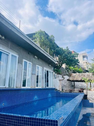 a house with a swimming pool next to a building at Homestay Thác Liên Khương in Ðưc Trọng