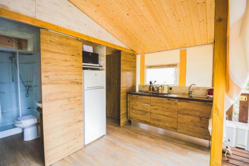 a kitchen with wooden walls and a white refrigerator at Camping Trasimeno in Passignano sul Trasimeno