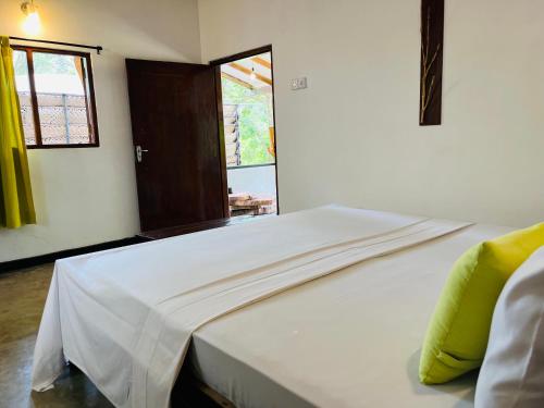 a white bed in a room with a window at Funky Leopard Safari Lodge Bordering Yala National Park in Kataragama