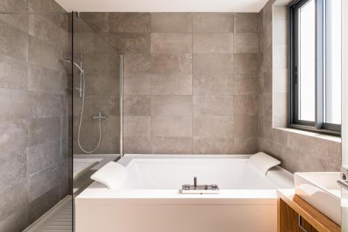ノヴァリャにあるOlea Residences & Villasのバスタブとシャワー付きのバスルーム