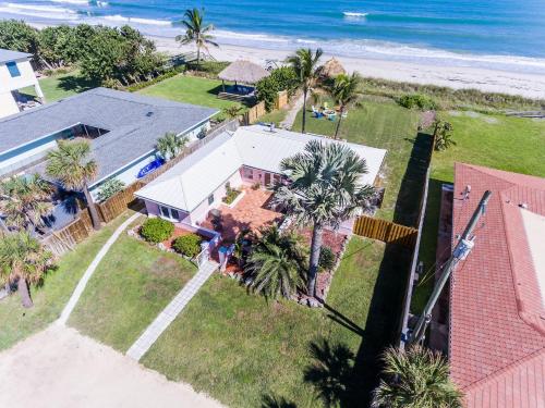 an aerial view of a house with palm trees and the beach at Family Retreat At The Beach - Direct Oceanfront! in Indialantic