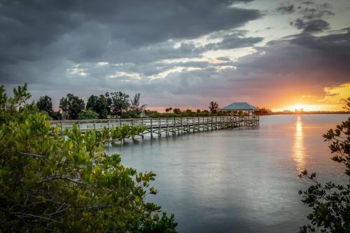 a dock on the water with a sunset in the background at Family Retreat At The Beach - Direct Oceanfront! in Indialantic