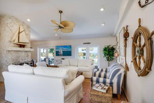 a living room with white furniture and a ceiling fan at Family Retreat At The Beach - Direct Oceanfront! in Indialantic