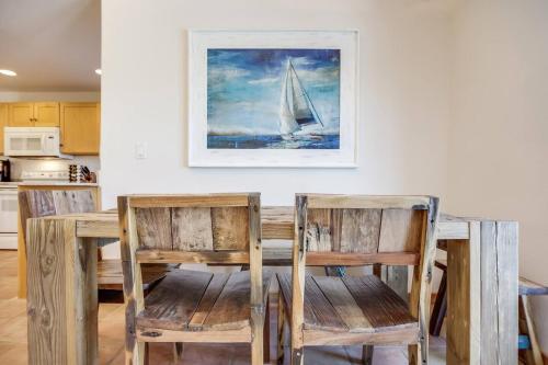 a dining room table with two chairs and a sail boat on a painting at Family Retreat At The Beach - Direct Oceanfront! in Indialantic