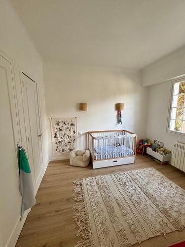 - une chambre bébé avec un lit bébé et un tapis dans l'établissement Maison à 4km de Hossegor, à Bénesse-Maremne