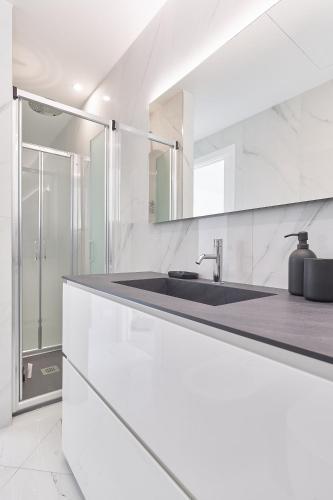 a white kitchen with a sink and a shower at The Italian Lady - Unit 1 in Alassio