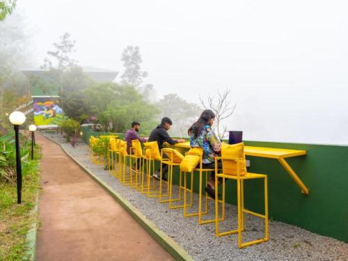 a group of people sitting at a table on a train at The Hosteller Munnar in Munnar