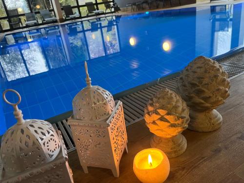 a table with candles and lanterns next to a swimming pool at Goldener Hahn B&B Baiersbronn - Ferienwohnungen mit Hygge Pool & Sauna in Baiersbronn