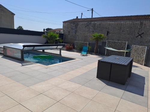 un patio avec un banc et une piscine dans l'établissement Chambre chez l'habitant, à La Ronde