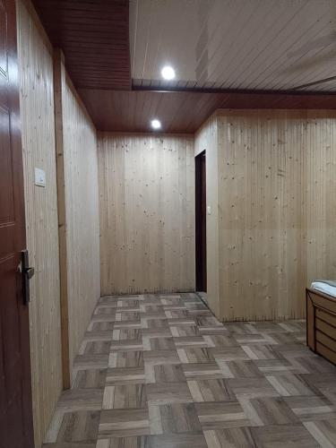 an empty room with wooden walls and a door at Exotic Mount View in Phata