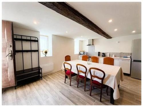 une salle à manger avec une table et des chaises et une cuisine dans l'établissement Maison normande, à Gouffern en Auge