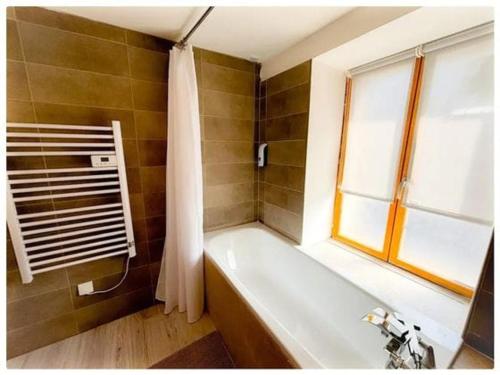 une salle de bain avec une baignoire et une fenêtre dans l'établissement Maison normande, à Gouffern en Auge