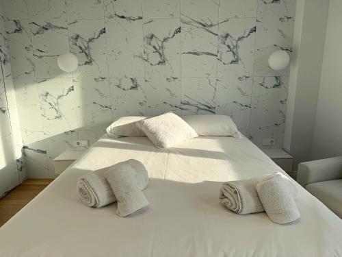 una camera da letto con un letto bianco con asciugamani sopra di Design and style next to Playa de Valencia a Valencia