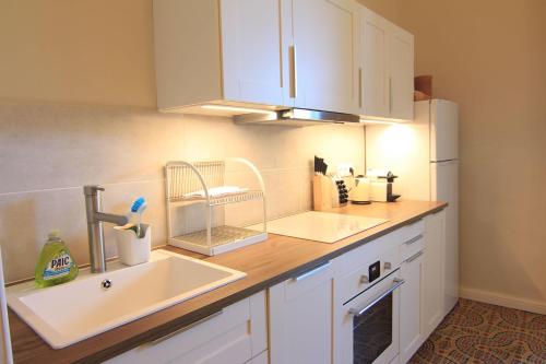 a kitchen with a sink and a white refrigerator at Cinq & Sept LGBT Resort for men in Roujan