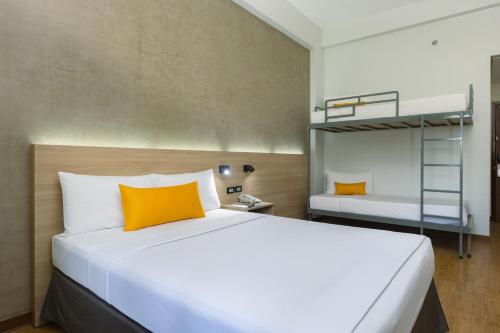 a bedroom with a large white bed with orange pillows at Microtel by Wyndham General Santos in General Santos