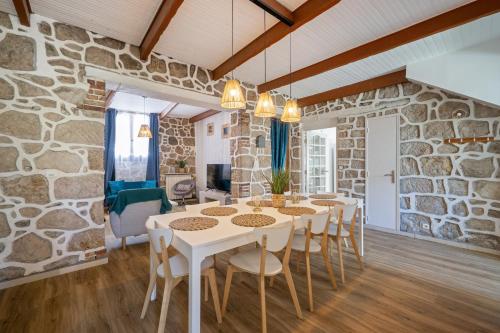 Cette chambre est dotée d'un mur en pierre, d'une table et de chaises. dans l'établissement Maison de ville familiale, 5 chambres, terrasse, à 20 minutes du centre ville, à Nice