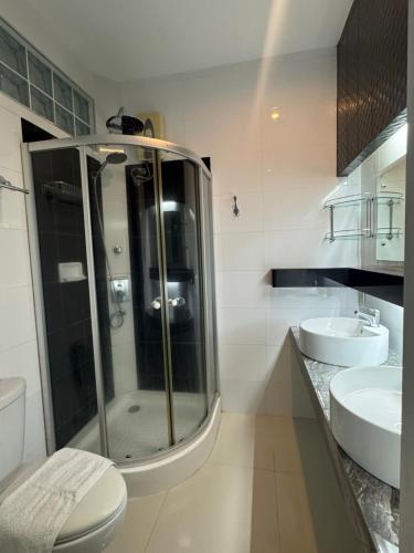 a bathroom with a shower and a toilet and a sink at Anavada Suites - Davao City in Davao City