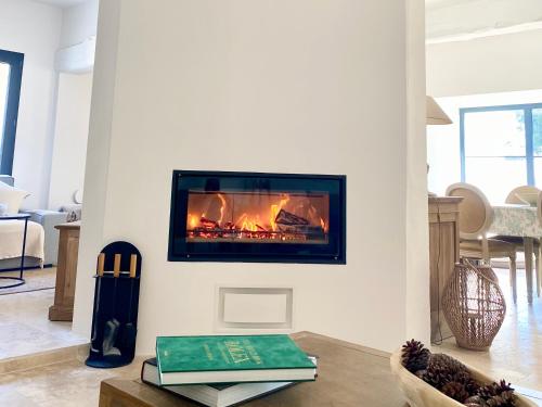 un salon avec une cheminée sur le mur dans l'établissement Bastide La Mérigot - Maussane-les-Alpilles, à Maussane-les-Alpilles