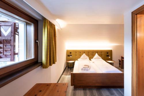 a hotel room with a bed and a window at Hotel Platz in Ortisei