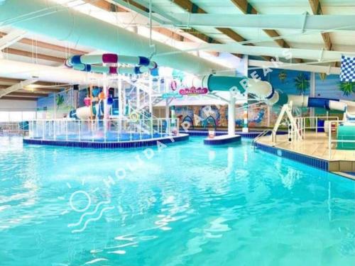 a large indoor swimming pool with a water slide at Coopers Corner - Stylish 2 bedroom home, Seal Bay - Pets Welcome in Selsey