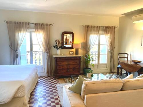 a bedroom with a bed and a couch and a mirror at Cinq & Sept LGBT Resort for men in Roujan