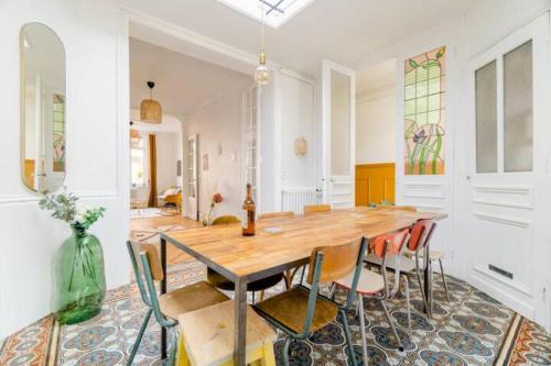 une salle à manger avec une table et des chaises en bois dans l'établissement Large Maison de ville 5 chambres avec jardin saint maur proche centre ville lille, à La Madeleine