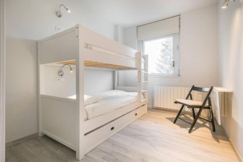 Un dormitorio con una litera con un escritorio y una silla. en Apartarent 1500 - Apartamento Letassi, en Baqueira Beret
