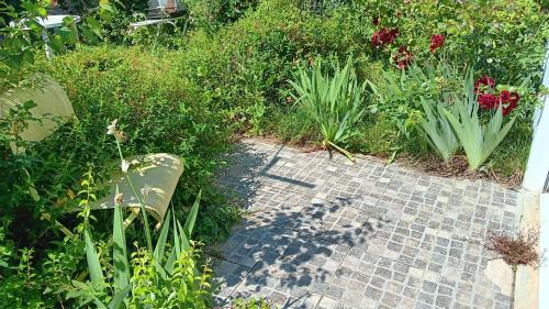 a garden with flowers and a brick walk way at L Escapade Médocaine Guest Room with Private Driver in Le Taillan-Médoc