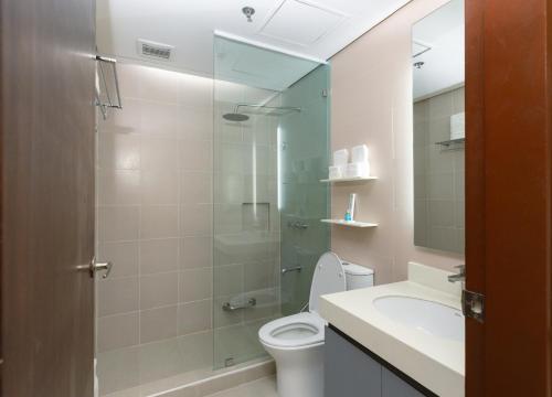 a bathroom with a shower and a toilet and a sink at Microtel by Wyndham General Santos in General Santos