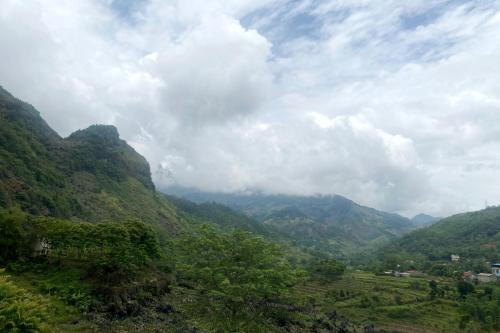 a view of a mountain valley with clouds and trees at Na Tau Homestay & Restaurant in Yên Minh