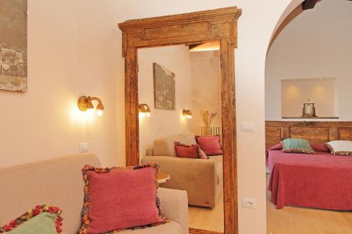 a living room with a couch and a mirror at Il Palazzo dei Diavoli in Montepulciano