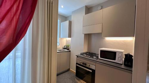 a small kitchen with a microwave and a stove at Residence Lungomare - Charming apartments in Riccione