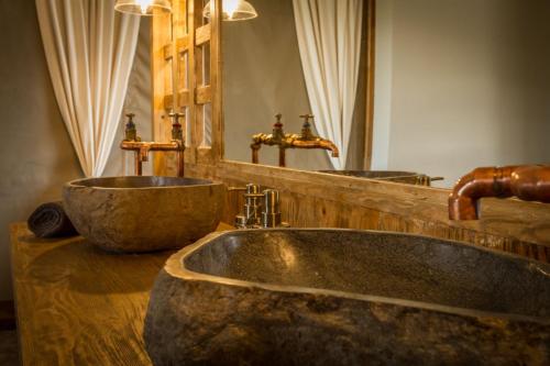 a bathroom with a stone sink and a mirror at Imagine Africa Luxury Tented Camp in Balule Game Reserve