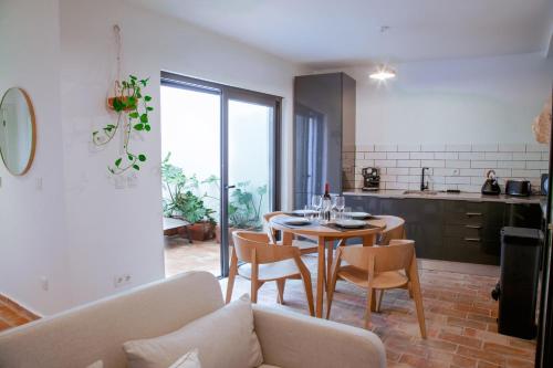a kitchen and dining room with a table and chairs at Mar-Ria 3 in Fuzeta