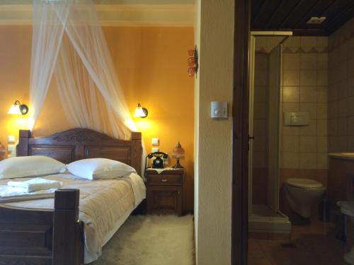 a bedroom with a bed and a bathroom with a shower at Archontiko Tsiboni in Elati Trikalon