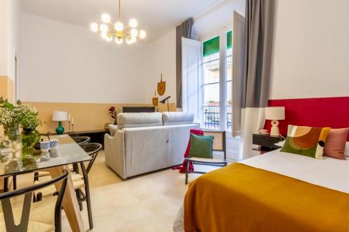 una habitación de hotel con una cama y un sofá en Hauzify I Loft Tura, en Sant Feliu de Guíxols