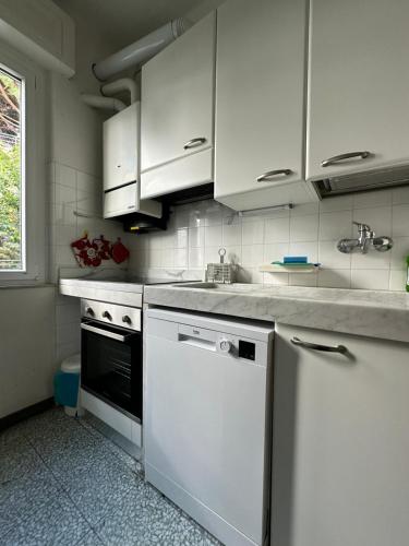 モネーリアにあるCasa Bianca 4 - confortevole in centro a Monegliaの白いキャビネットと食器洗い機を備えたキッチン