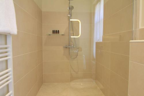 a bathroom with a shower with a glass door at Cinq & Sept LGBT Resort for men in Roujan