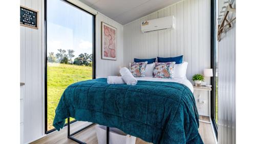 a bedroom with a bed and a large window at Gold Fields by Tiny Away in Ross Creek