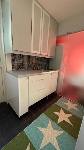 a kitchen with white cabinets and stars on the floor at Villa South Beach in Karlskrona